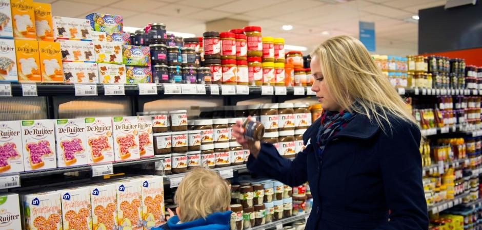 Vrouw en kind in boodschappenkar supermarkt