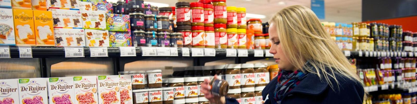 Vrouw en kind in boodschappenkar supermarkt